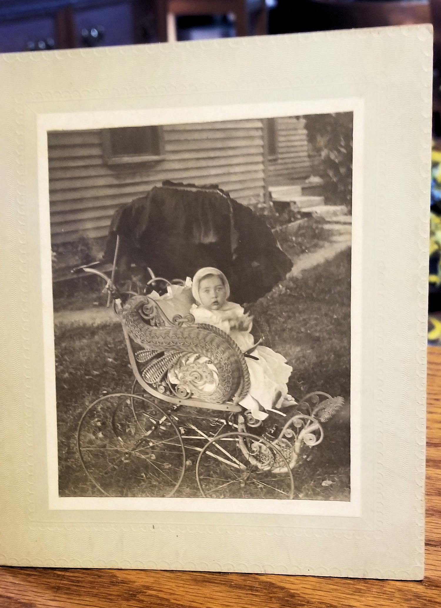 Baby Girl in
                        Ornate Wicker Victorian Baby Stroller; Antique
                        Cabinet Photo