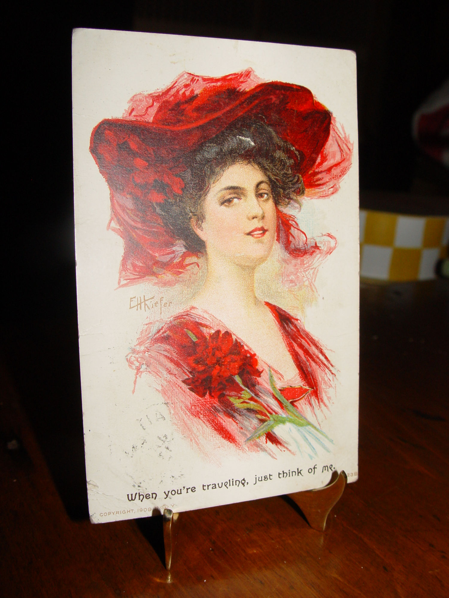 EH Kiefer
                                                "Traveling, think
                                                of me" Raven haired
                                                woman in Red Hat 1908
                                                Postcard